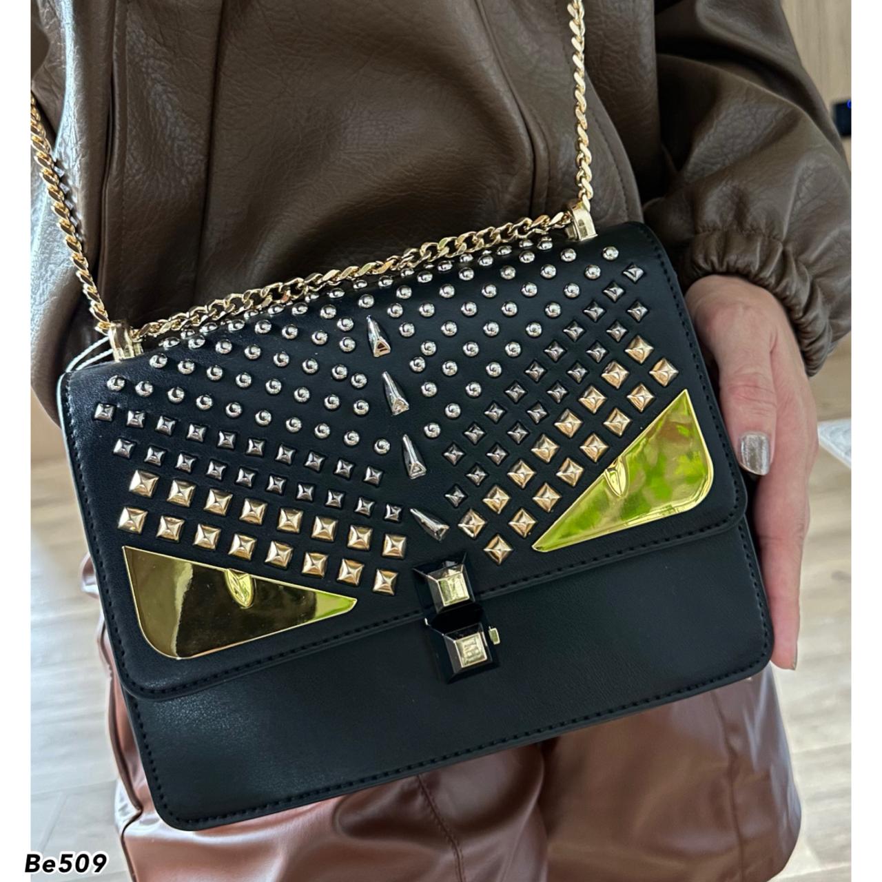 Bolso negro apliques plateado ojos y cadena dorado  22cm* 9cm* 17cm  C- 23196-1